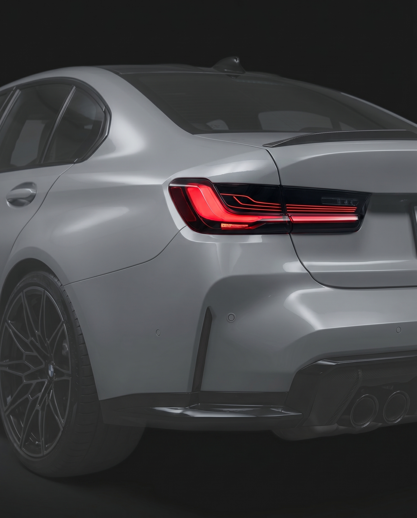 CSL laser-style LED tail lights for BMW G80 M3 and G20 3-Series, smoked lens, red laser signature lit, vehicle ghosted in dark studio