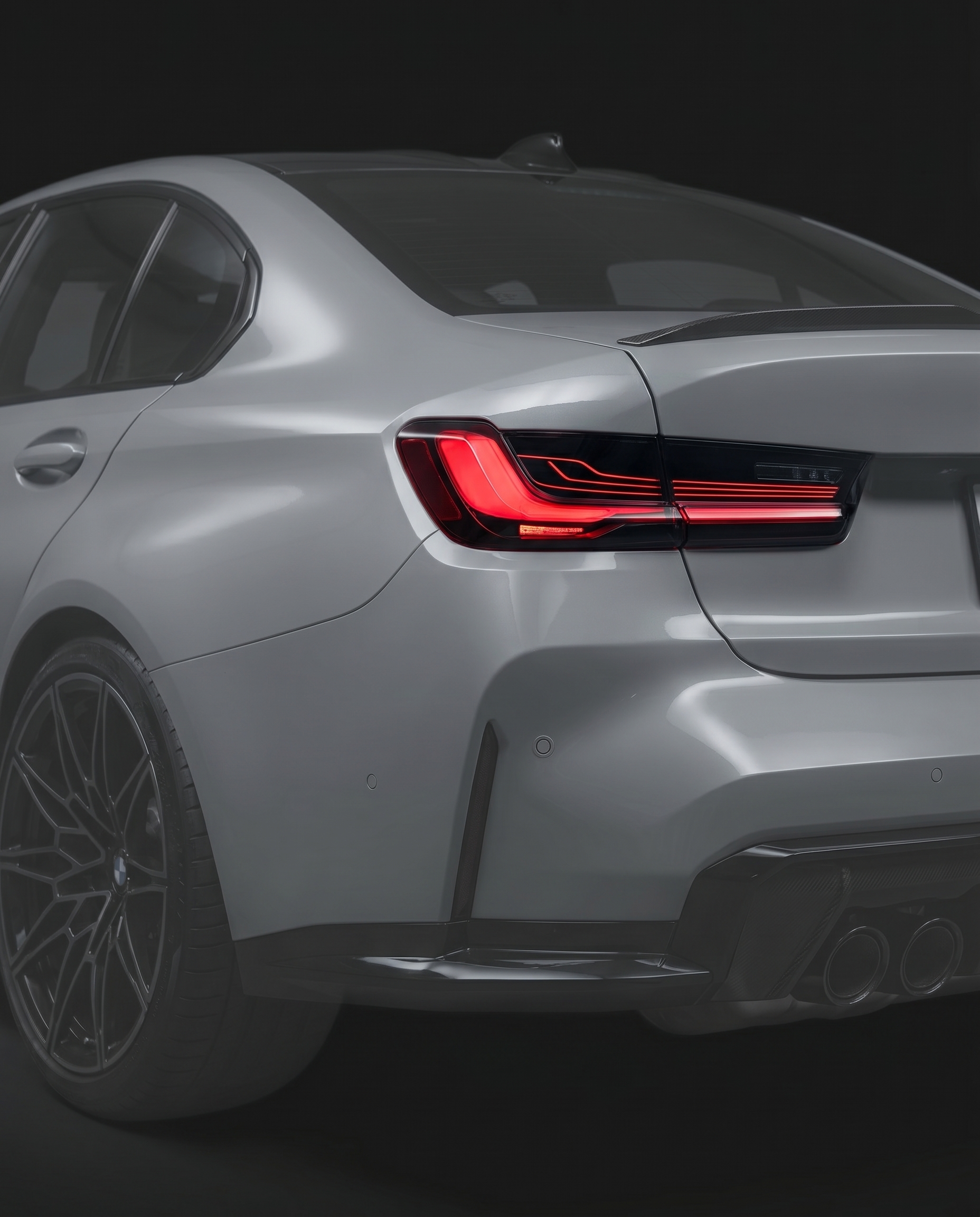 CSL laser-style LED tail lights for BMW G80 M3 and G20 3-Series, smoked lens, red laser signature lit, vehicle ghosted in dark studio