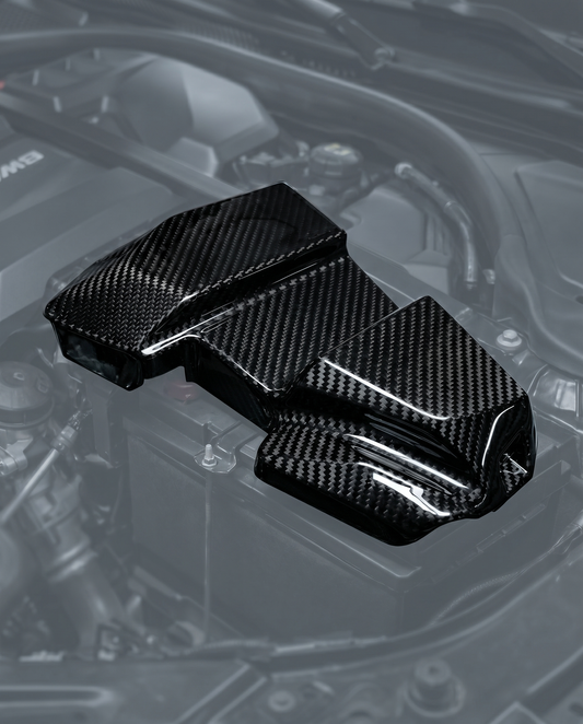 Gloss dry carbon fiber battery terminal cover for BMW G80 M3 G82 M4 G87 M2, engine bay ghosted, studio light reveals 2x2 twill weave