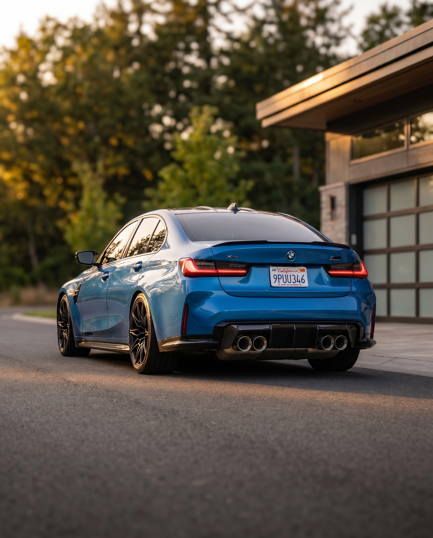 BMW G80 M3 rear at dusk with oversized brushed aluminum carbon exhaust tips, wide aggressive rear presence, lowered motorsport stance