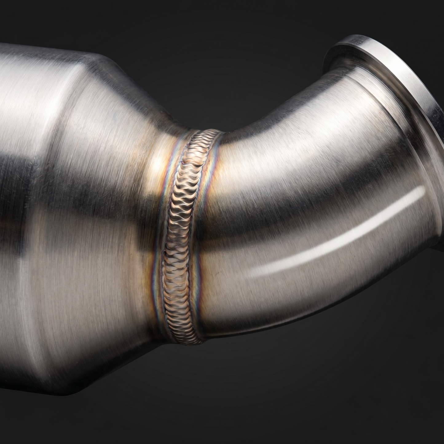 Macro of TIG weld bead where cat housing meets mandrel tube on BMW S58 stainless downpipe, crisp stacked-dime weld and heat tint