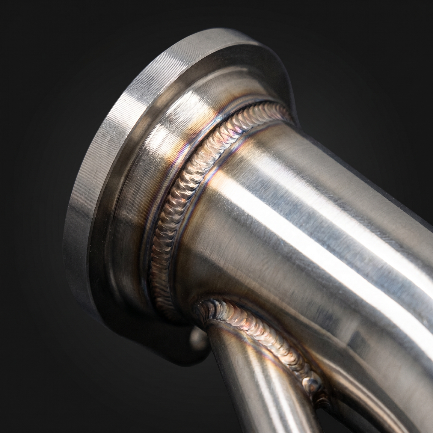 Macro of TIG weld bead and V-band flange on BMW G8X stainless equal-length midpipe, crisp stacked-dime weld and heat tint