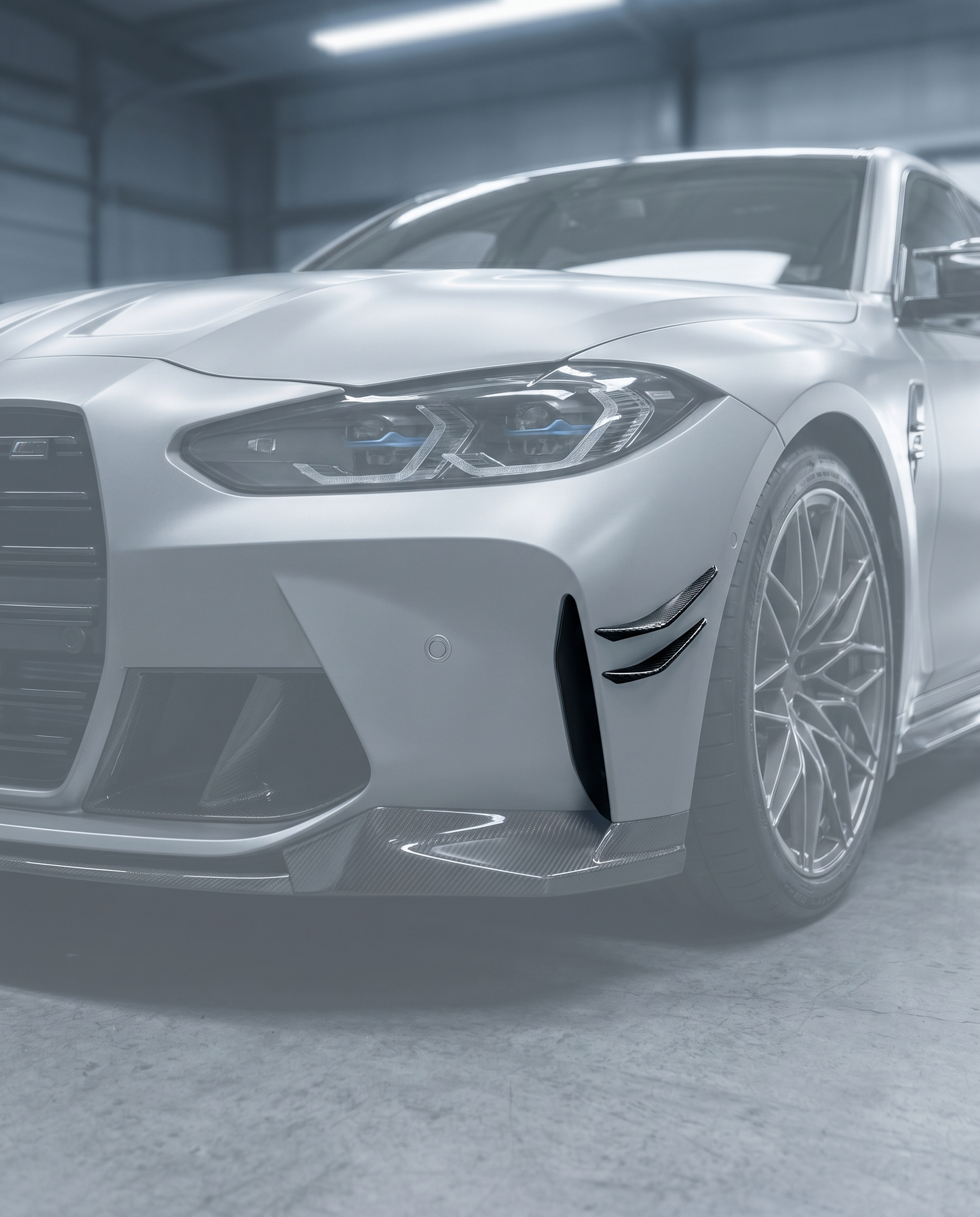 Carbon front canards stuck on ghosted BMW G80 M3 front bumper corner, aggressive aero flicks, blurred premium garage, OEM+ fit