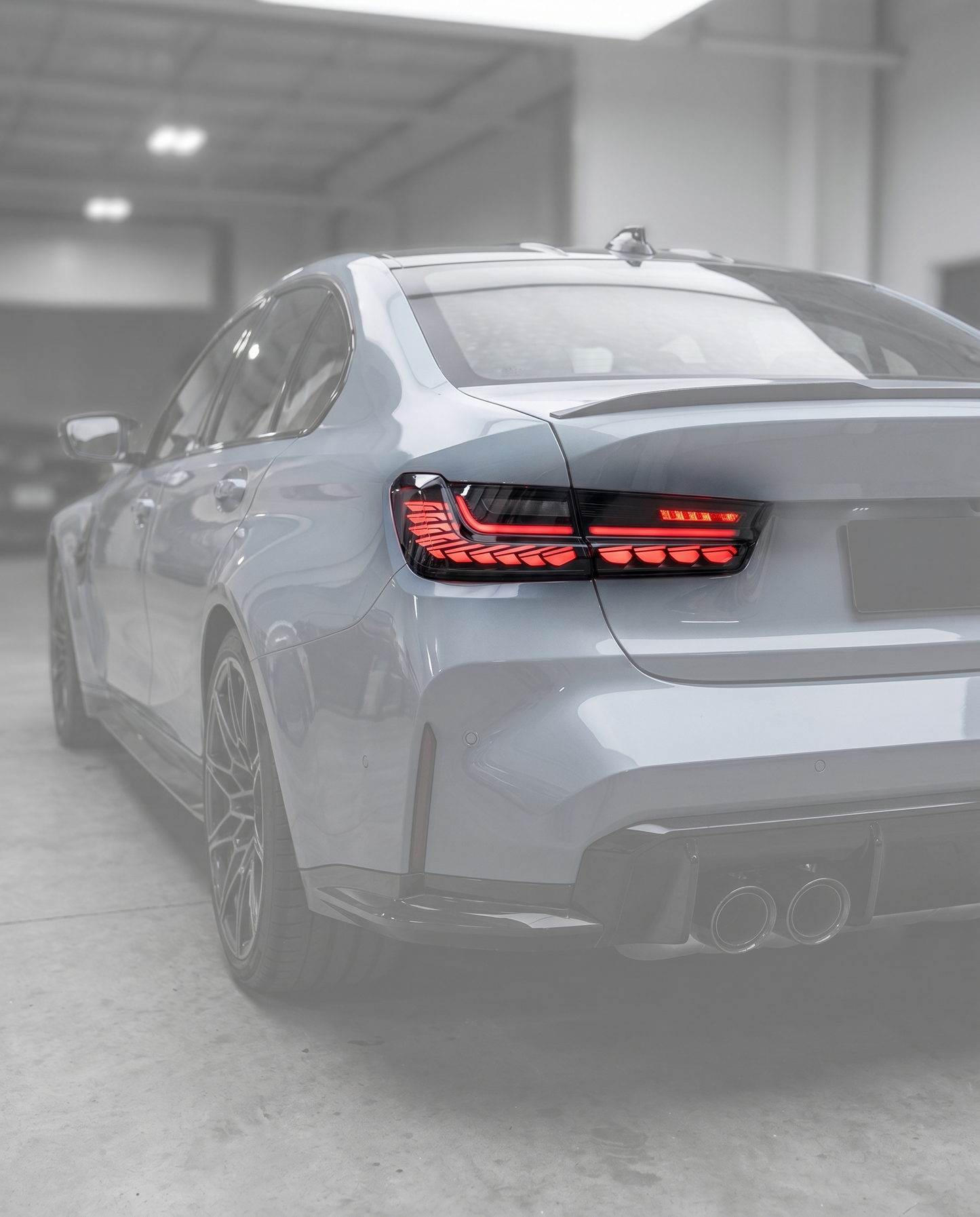 GTS clear LED tail lights installed on ghosted BMW G80 M3 rear, track-bred red signature lit in blurred premium garage, OEM fit