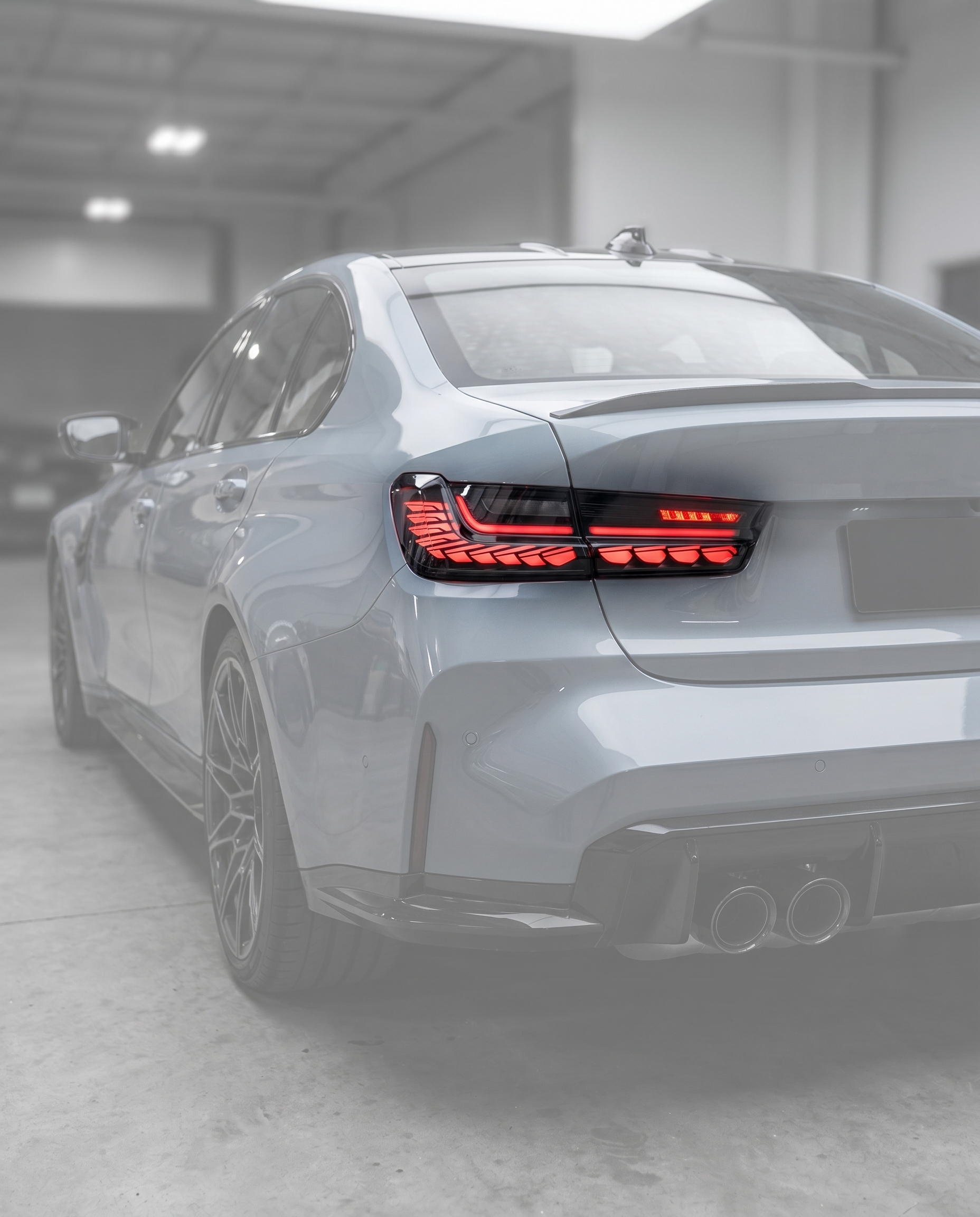 GTS clear LED tail lights installed on ghosted BMW G80 M3 rear, track-bred red signature lit in blurred premium garage, OEM fit
