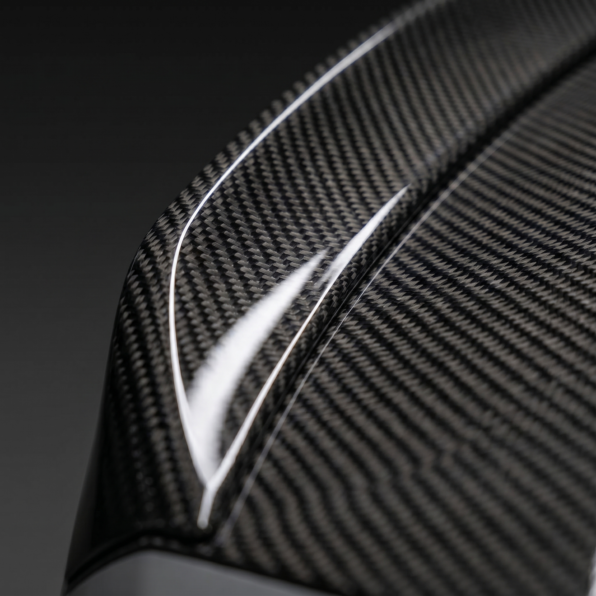 Macro of gloss 2x2 twill carbon weave on BMW G80 M3 CSL ducktail trunk lid edge, clean light-bar reflection and machined edge