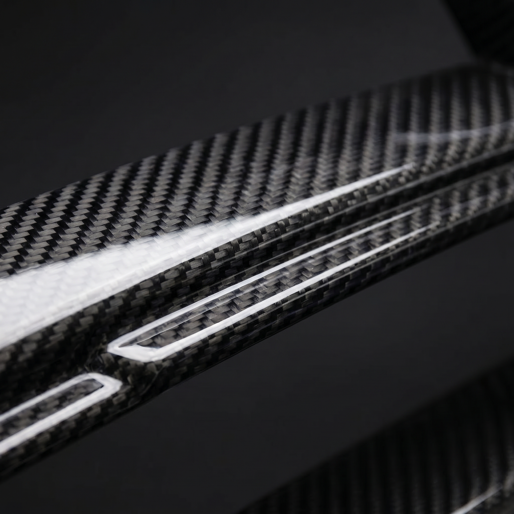 Macro of gloss 2x2 twill weave on CSL-style carbon front grille slat for BMW G8X, clear-coat depth and machined edge