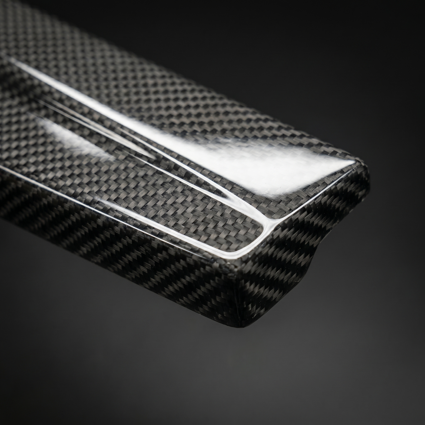 Macro of gloss 2x2 twill weave on carbon side skirt extension for BMW G8X, clear-coat depth and machined edge detail