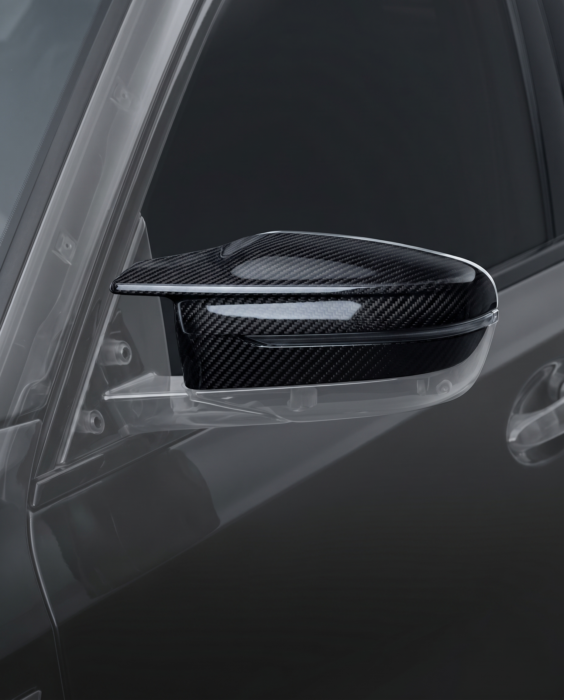 Gloss dry carbon mirror caps for BMW G80 M3, studio hero shot showing curved 2x2 twill weave and machined edge