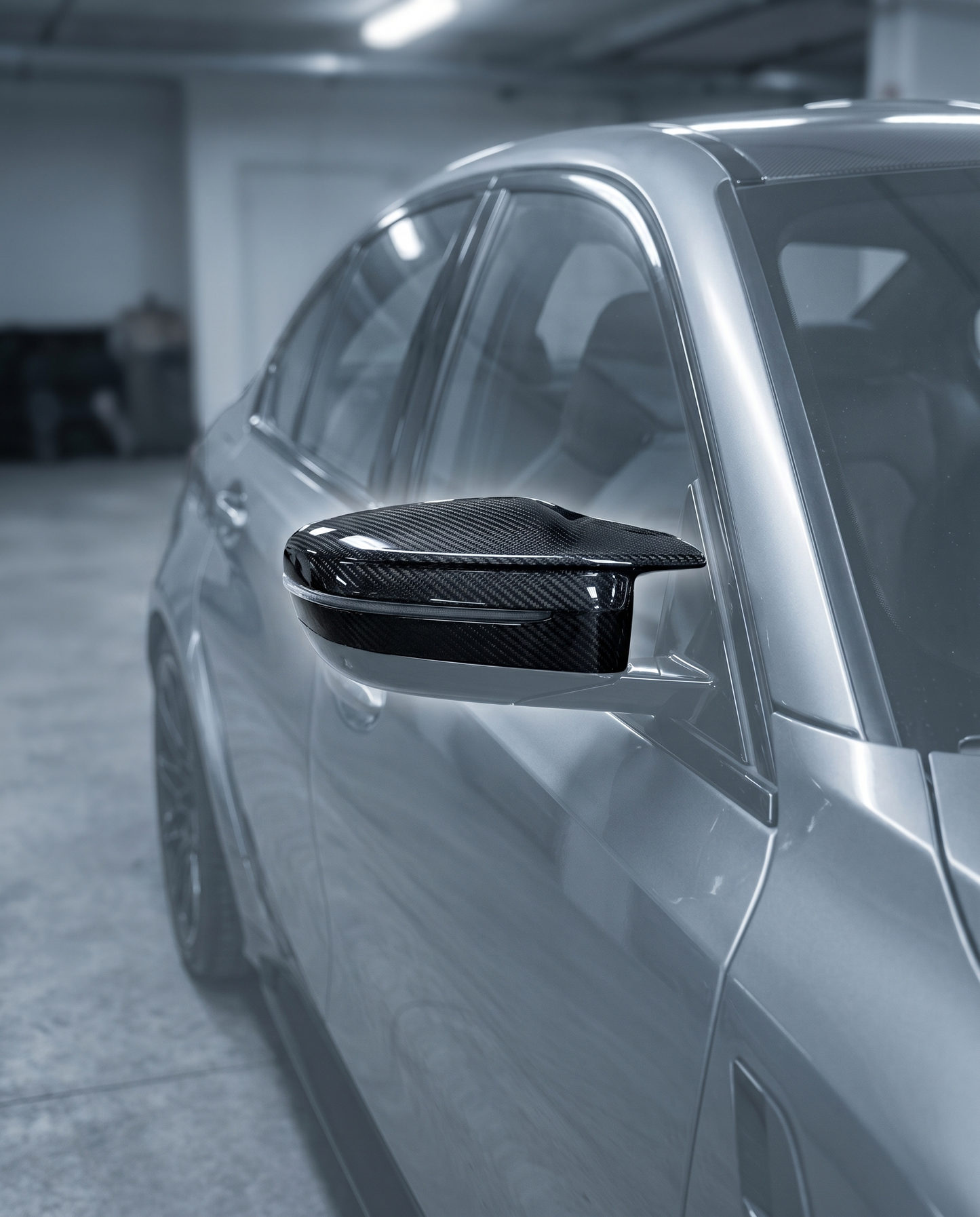 Gloss dry carbon mirror cap fitted on BMW G80 M3 side mirror, premium garage lighting shows clean direct-fit finish