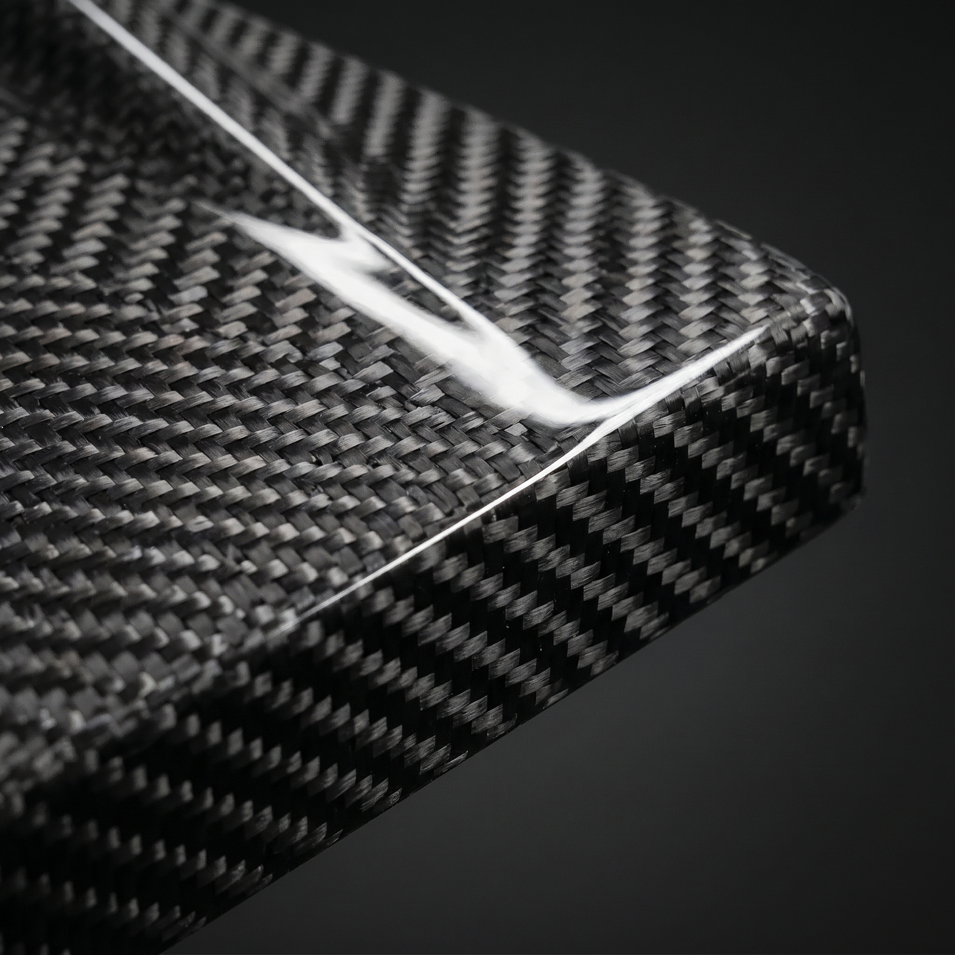 Macro of gloss 2x2 twill weave on MP-style carbon side skirt for BMW G80 M3, clear-coat depth and machined edge