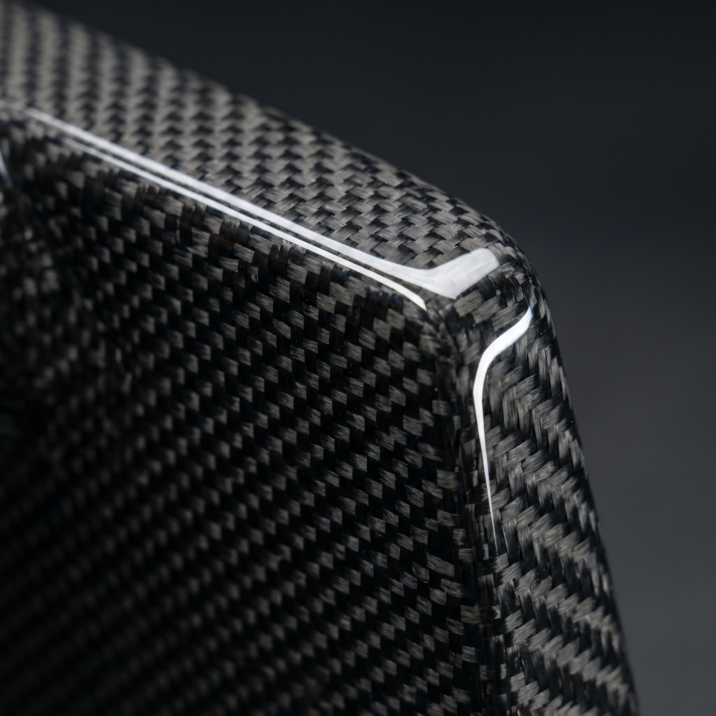 Macro of gloss dry carbon weave on SQ-style rear diffuser fin for BMW G90 M5, clear-coat depth and machined edge