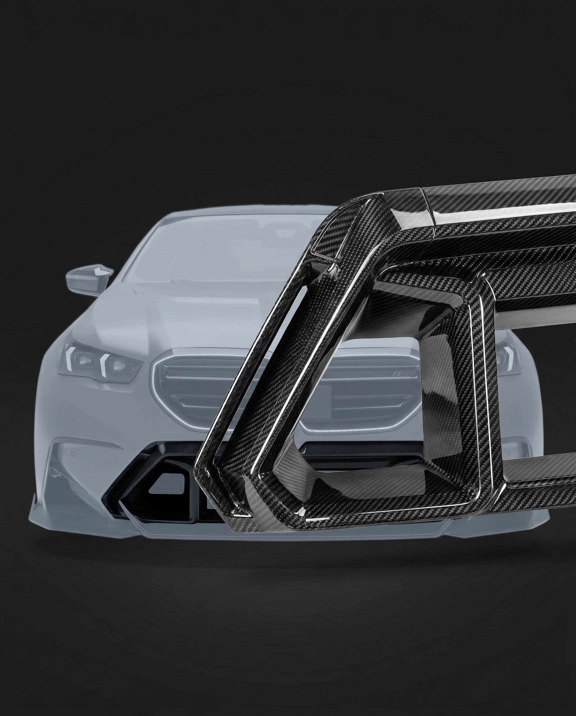 Gloss dry carbon front bumper center vent for BMW G90 M5, studio hero shot showing slats and carbon weave depth
