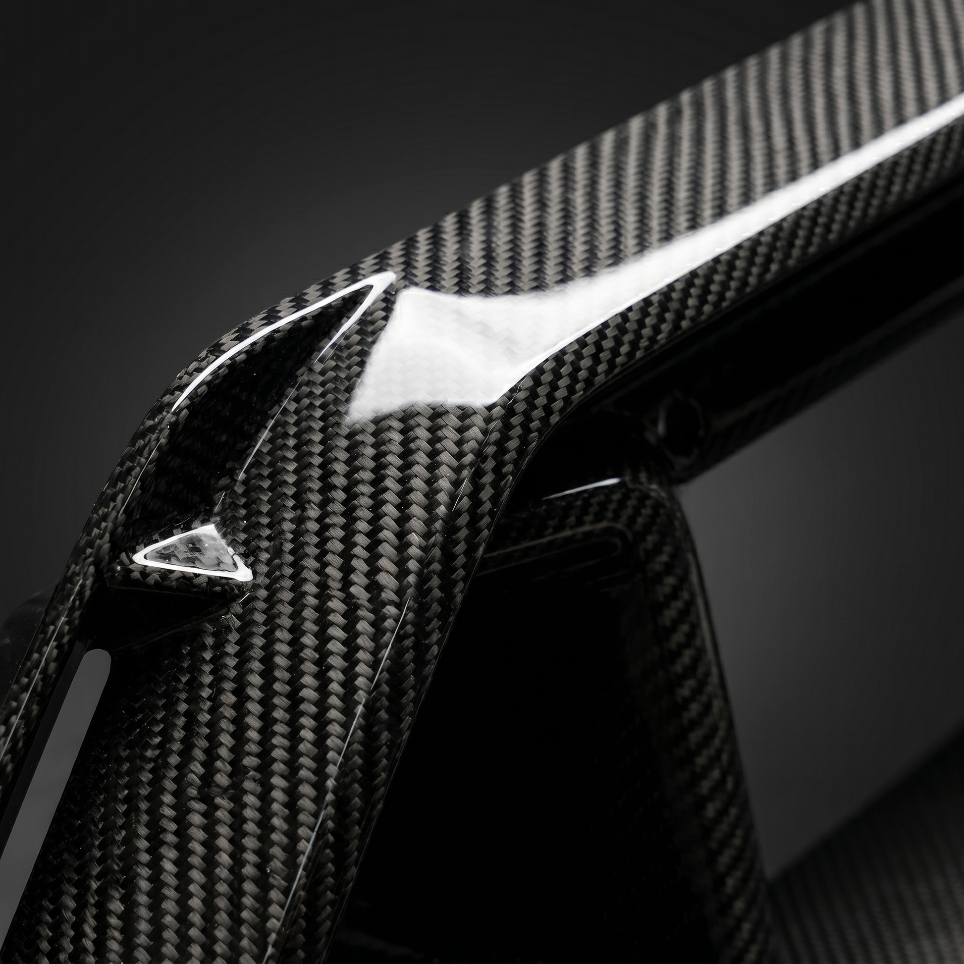 Macro of gloss dry carbon weave on G90 M5 front center vent, clear-coat depth and machined slat edge