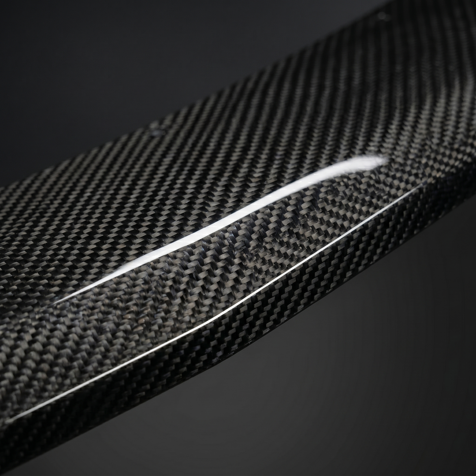 Macro of gloss 2x2 twill dry carbon weave on RZ-style front lip for BMW G90 M5, showing clear-coat depth and machined edge