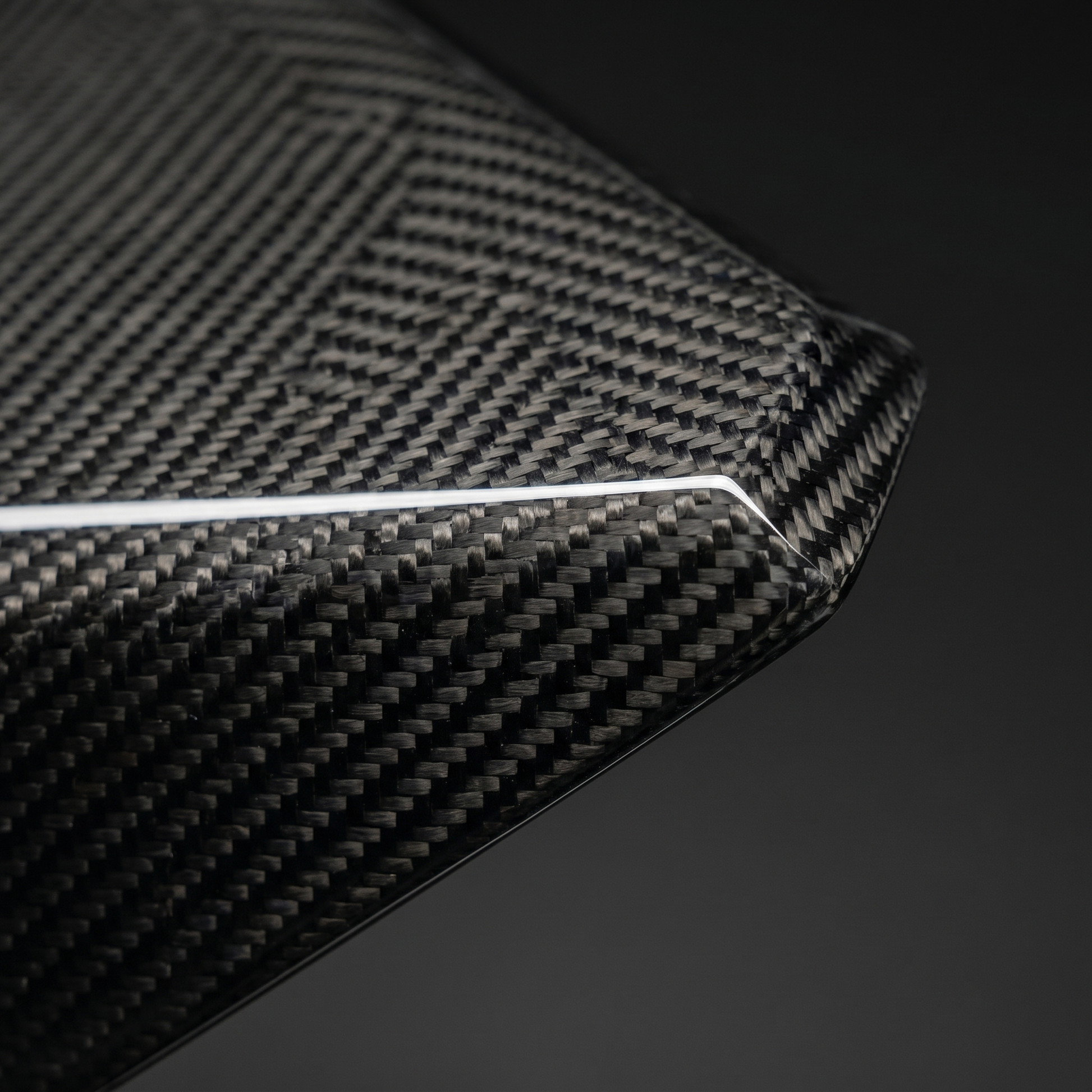 Macro of gloss 2x2 twill dry carbon weave on LAB-style front lip for BMW G90 M5, clear-coat depth and precise machined edge