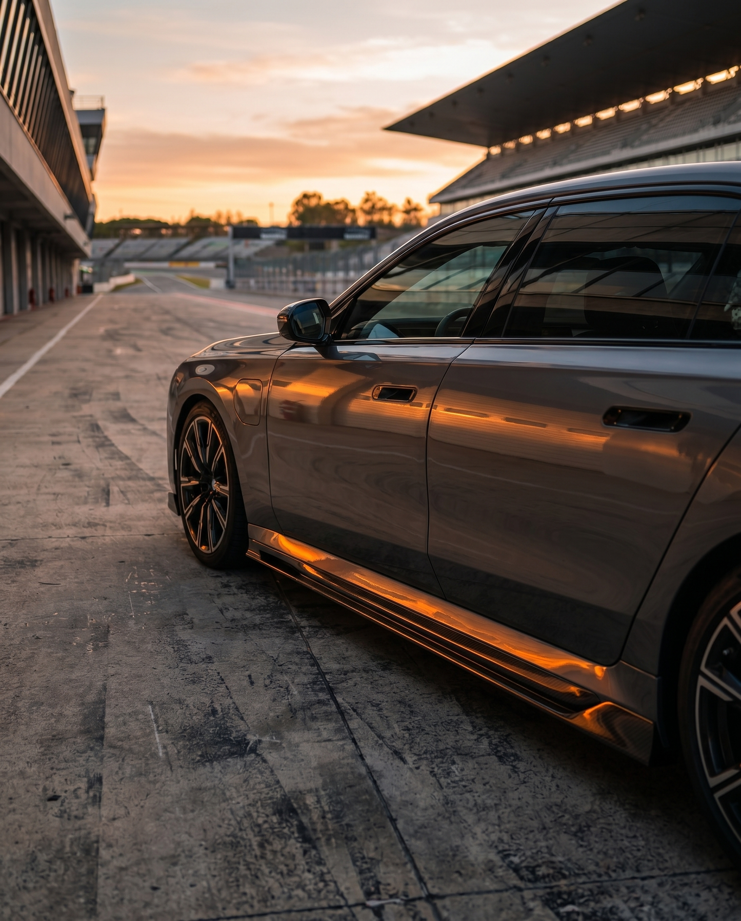 Gloss dry carbon RZ side skirts on 2025+ BMW G90 M5 at golden-hour dusk, lowered aggressive side profile in cinematic light