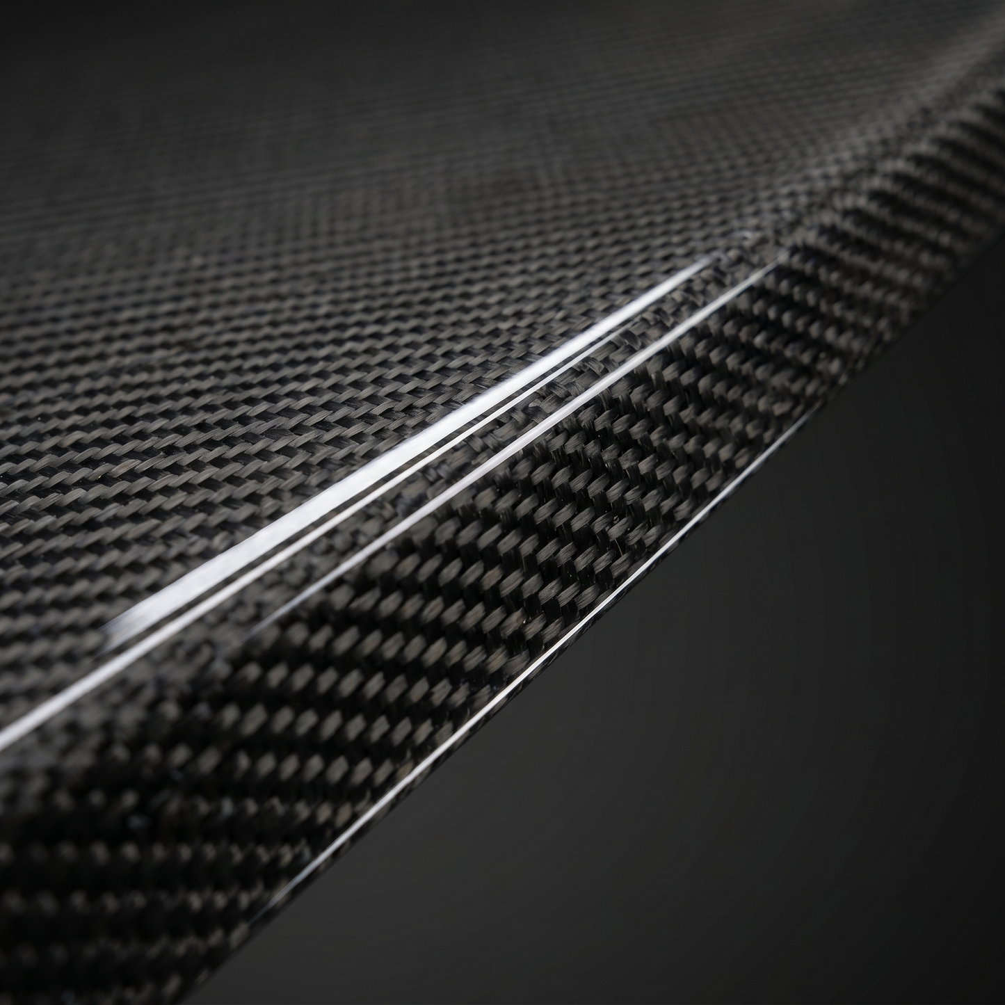 Macro of gloss 2x2 twill dry carbon weave on Type 1 front lip edge for BMW G90 M5, clear-coat depth and machined edge detail