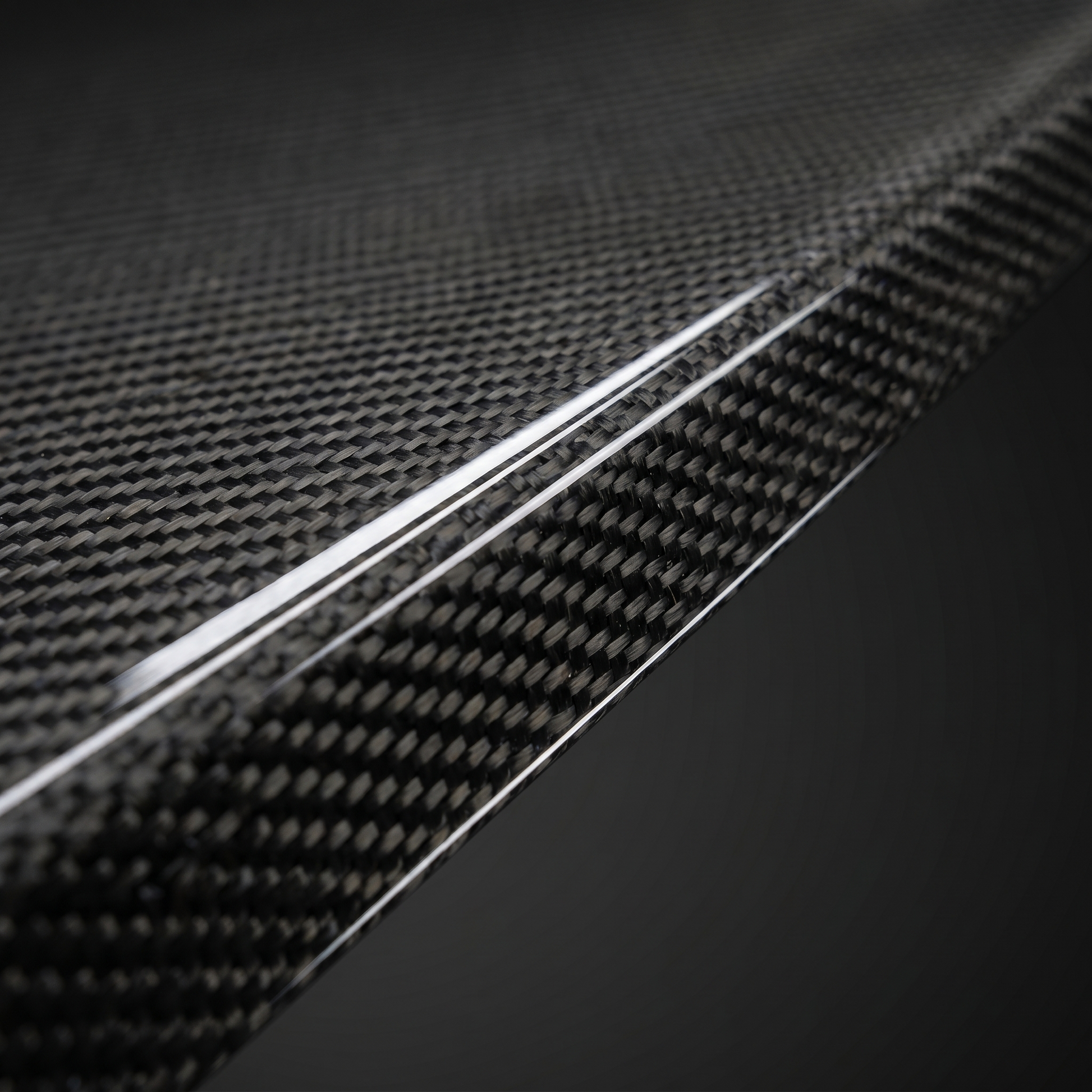 Macro of gloss 2x2 twill dry carbon weave on Type 1 front lip edge for BMW G90 M5, clear-coat depth and machined edge detail